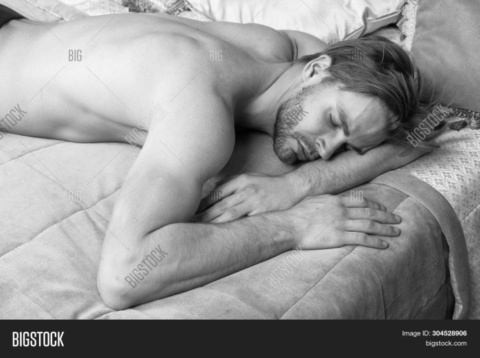 A naked man sleeps in bed