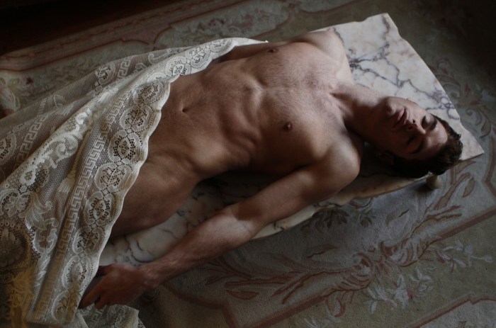 A handsome guy sleeps naked