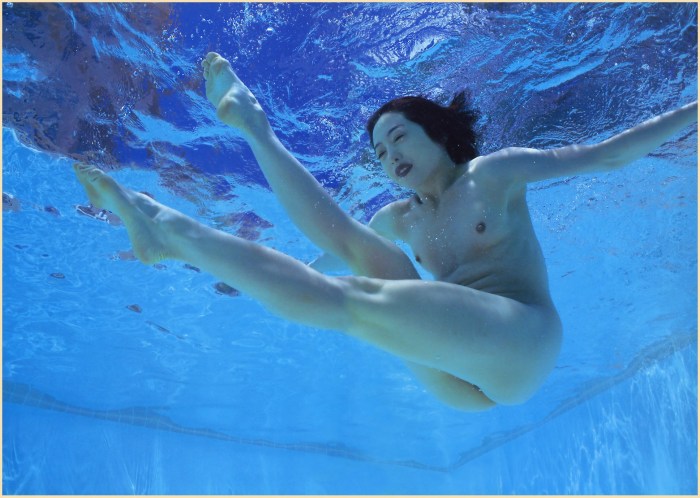 Naked brunette in the pool