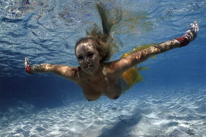 Naked women swim in the sea