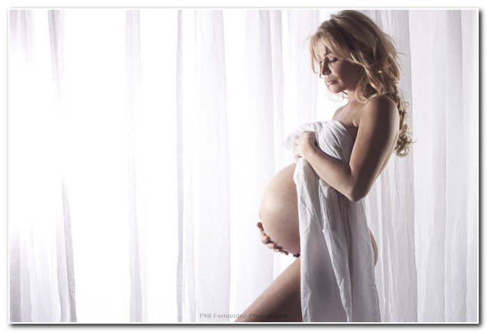 Photo of a pregnant woman's tummy on the background of a window