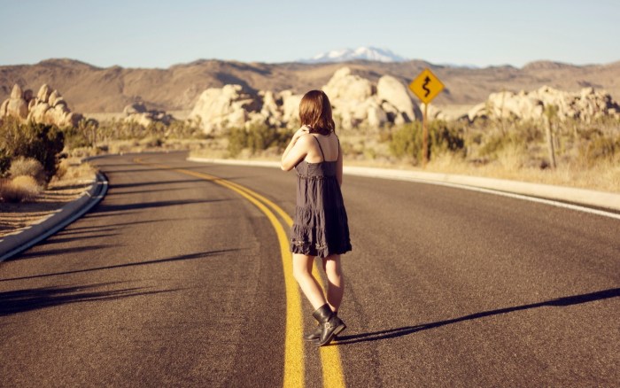 The girl is walking along the road