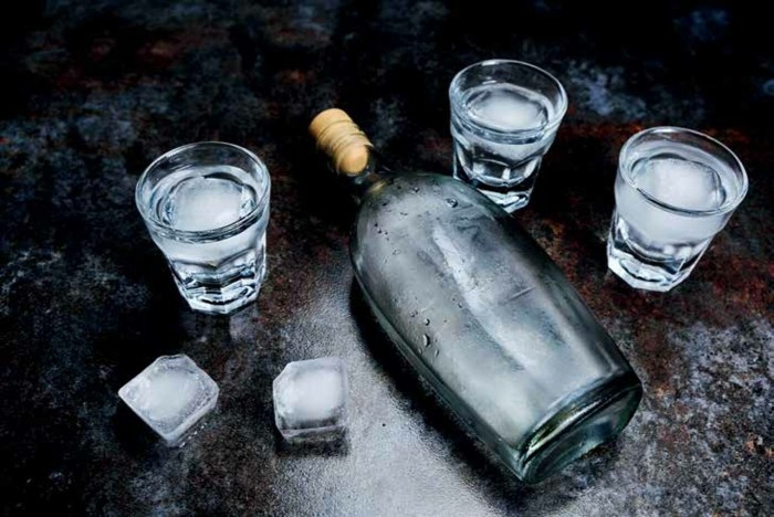 A bottle of vodka with a pile