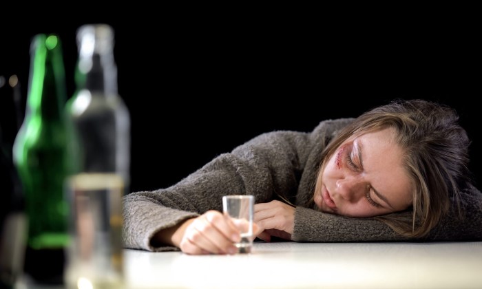 The woman sleeps at the table drunk