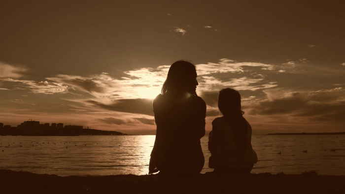 Mom and daughter silhouette at sunset