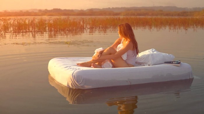 Girl on the mattress in the pool from above