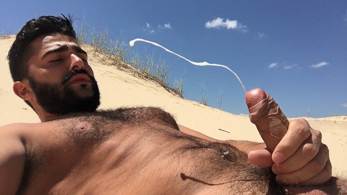 A naked man lies on the beach
