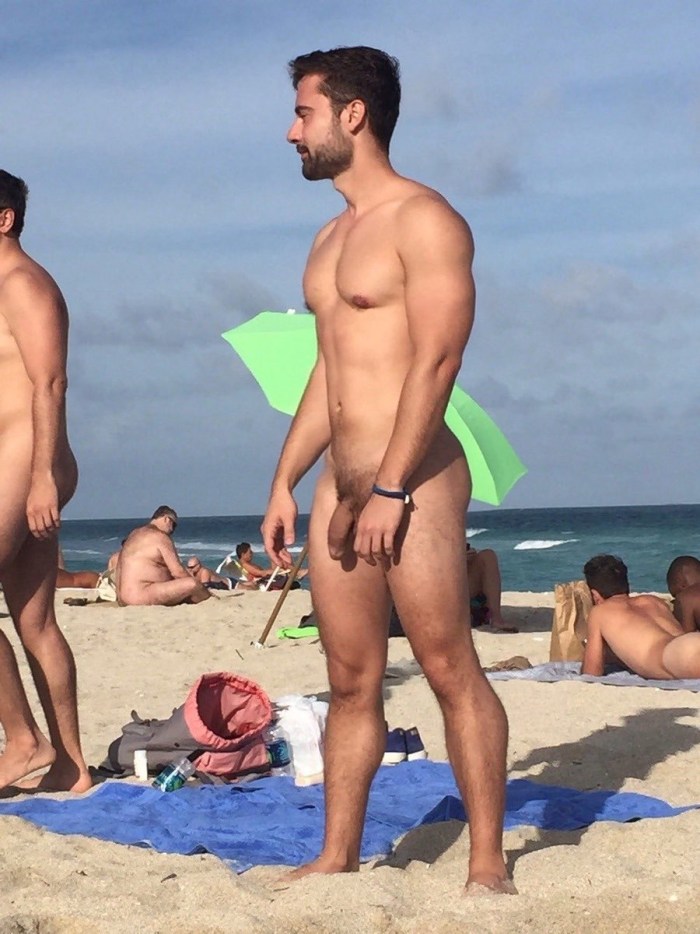 A naked man lies on the beach