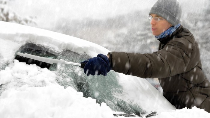 Cleans the car of snow