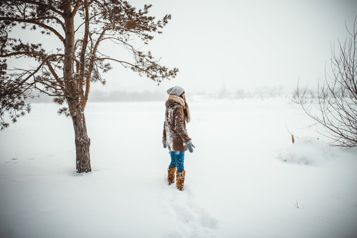 Girl in the winter in the forest with her back