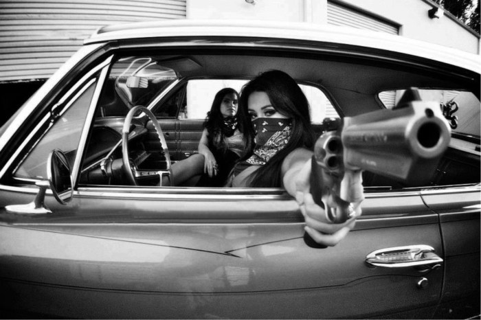 Girl with a gun in a car