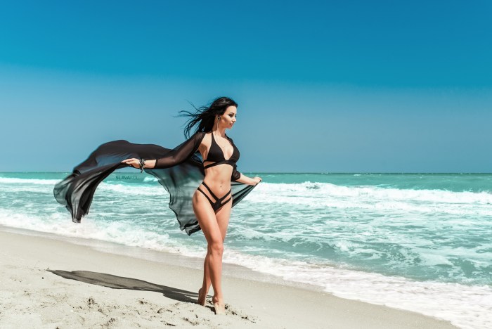 The girl sunbathes in thongs on the beach