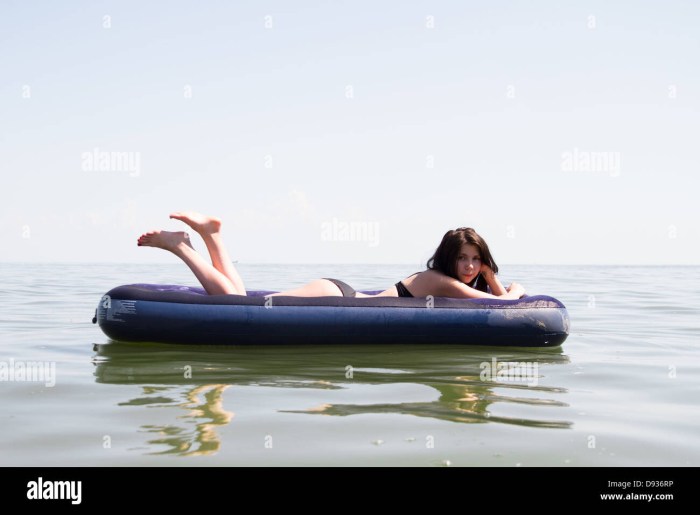 The girl tanes on an inflatable mattress