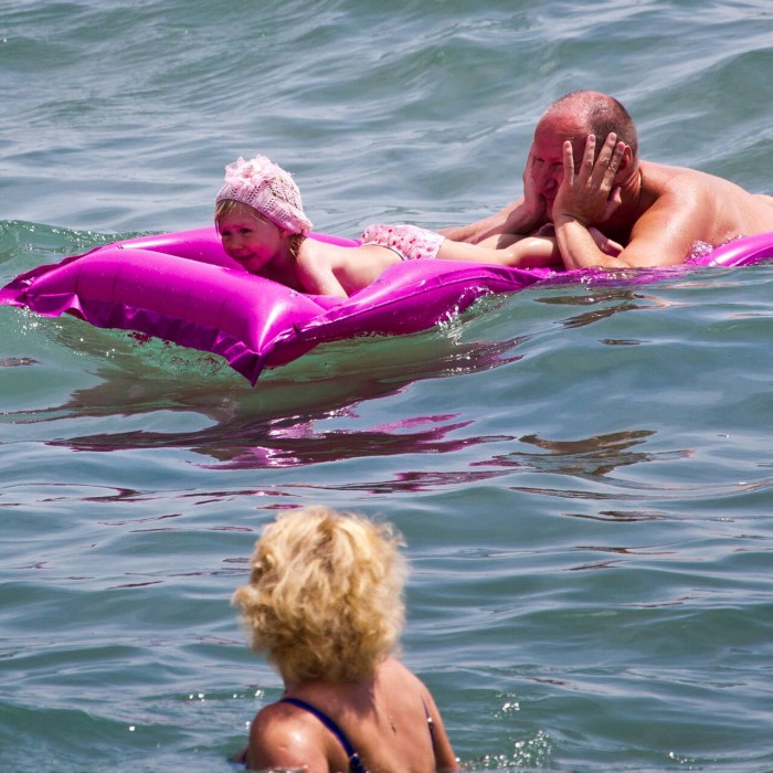 Girl on pink flamingos in the pool