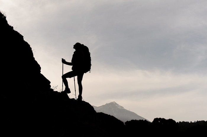 Man climbs the silhouette to the mountain