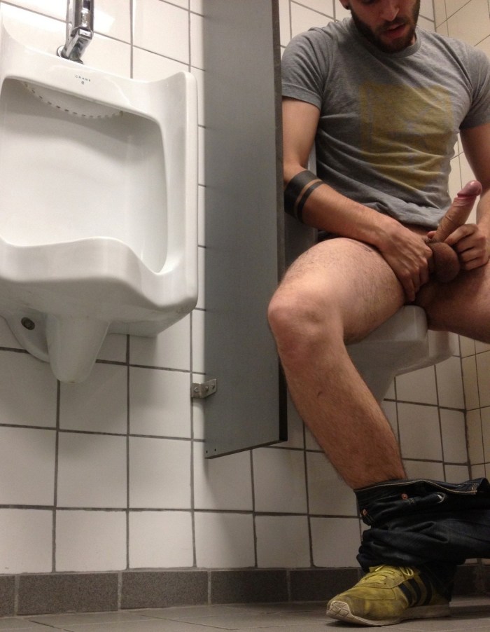 A handsome guy sits in the bathroom naked