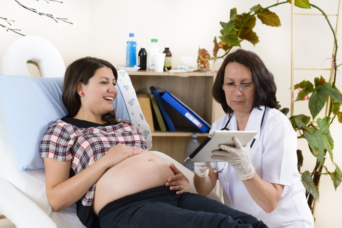 Photo of a pregnant woman sits at a reception