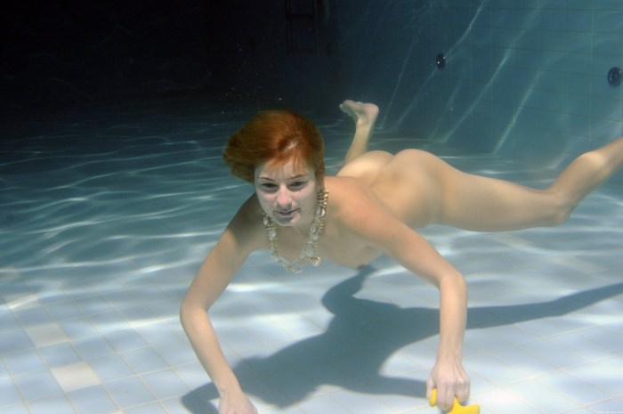 The girl bathes naked underwater in