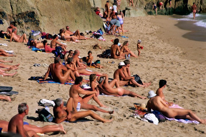 Couples sunbathe naked on the beach