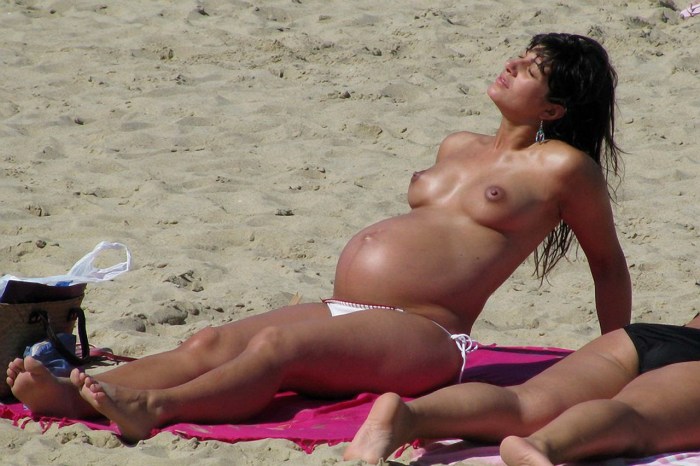 Pregnant topless on the shore