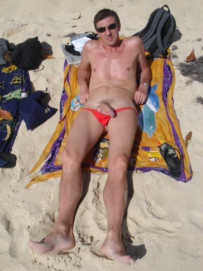Naked man on the beach in shorts